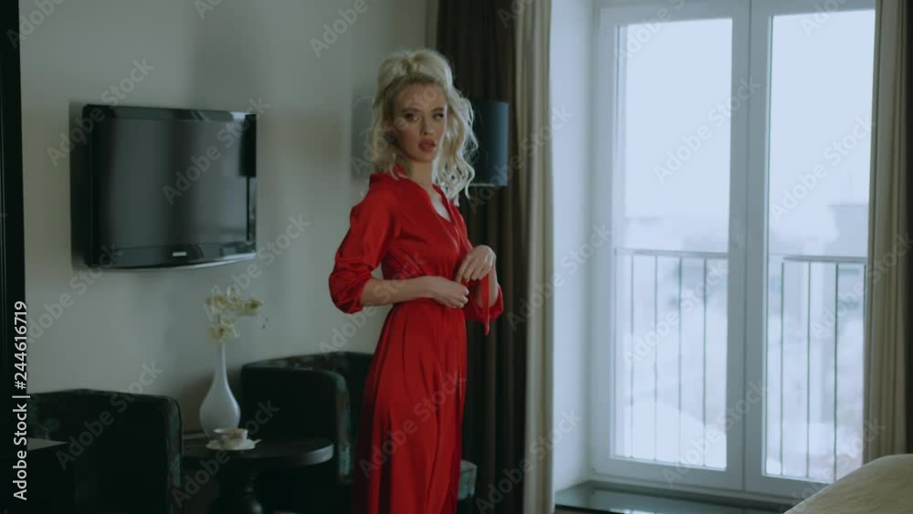 Tempting young woman is turning to camera, touching her silk gown. She is standing alone in living room. Shoot with RED RAVEN camera Tempting young woman is turning to camera, touching her silk gown. She is standing alone in living room. Shoot with RED RAVEN camera