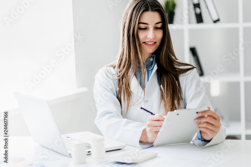 Female doctor working at office desk, healthcare professionals.