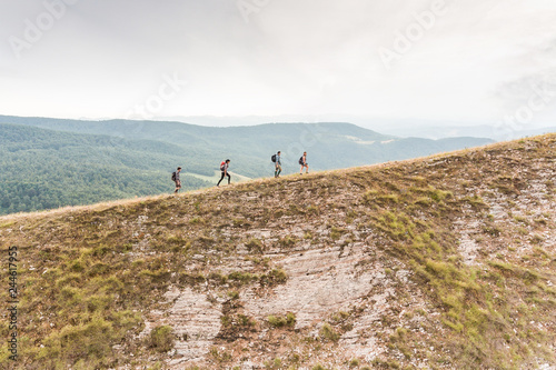 People hiking on top edge of mountain