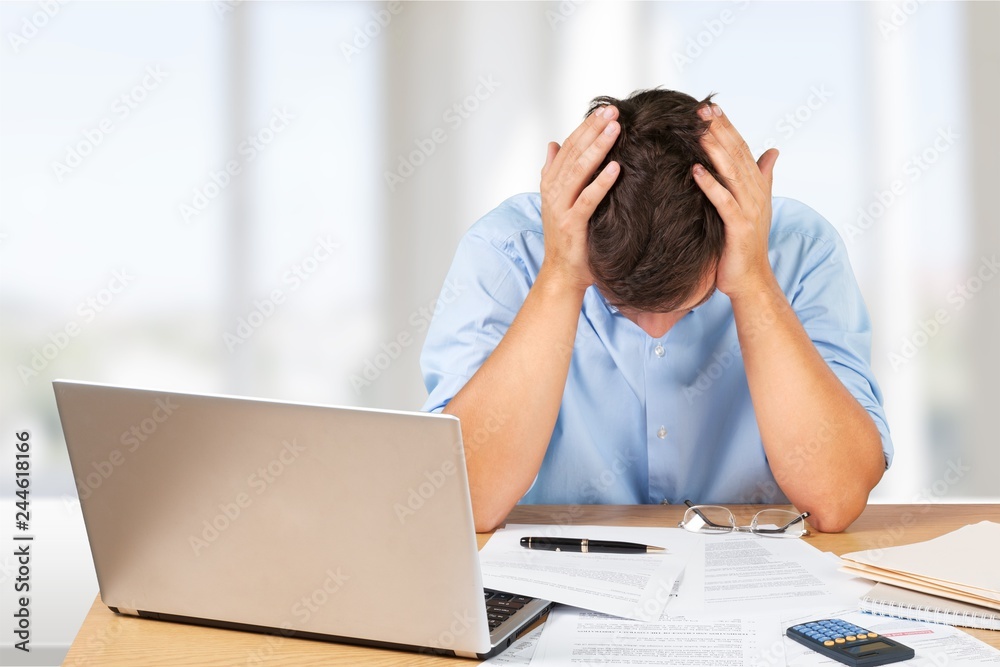 Tired young businessman with many papers Tired young businessman with many papers