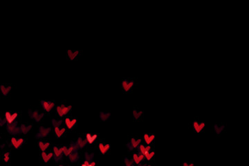 Red heart valentine bokeh lights against a black background