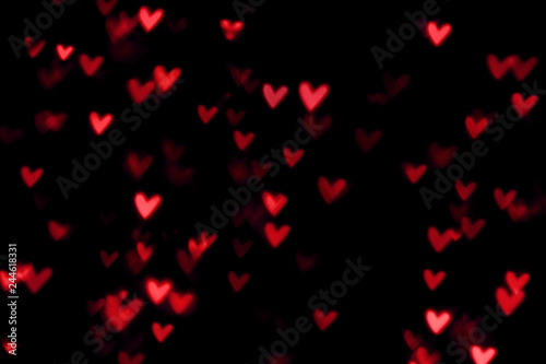 Red heart valentine bokeh lights against a black background
