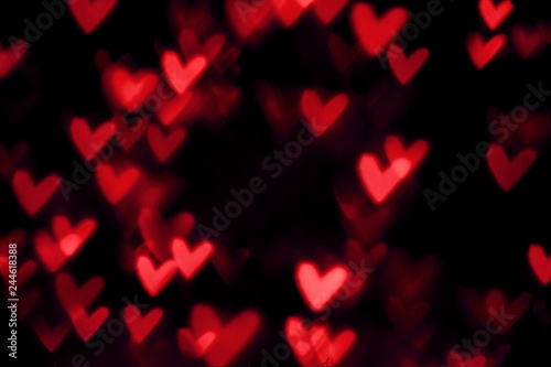 Red heart valentine bokeh lights against a black background