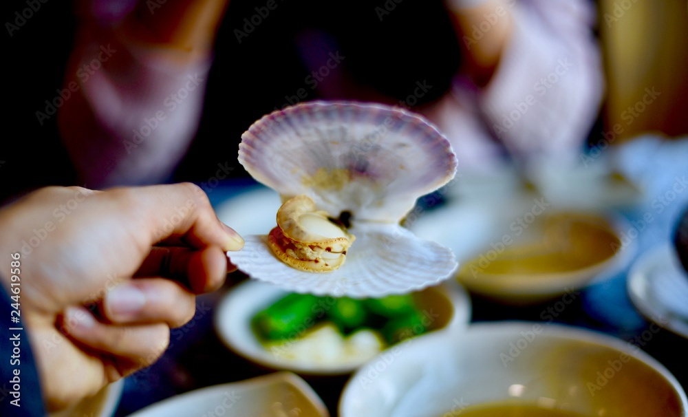 Eating fresh scallops in Korea fish market in Seoul Photos Adobe Stock