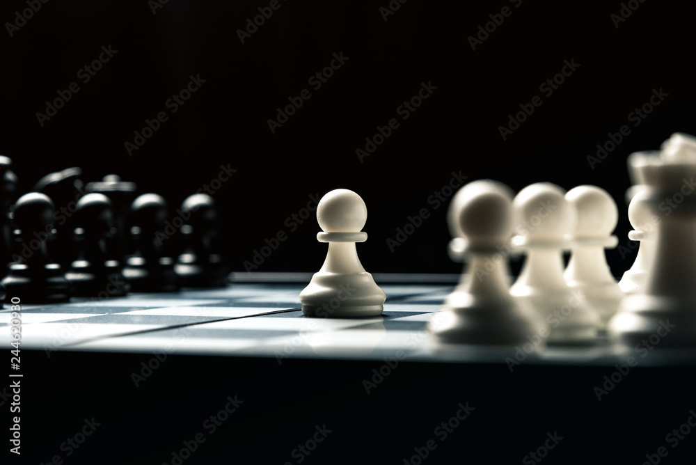 Chess board with black and white chess facing each other. White pawn goes on the attack Chess board with black and white chess facing each other. White pawn goes on the attack