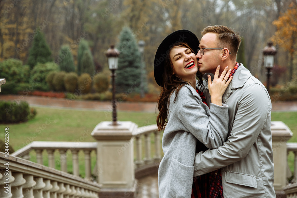 Couple in love. Happy couple hugging and smiling. Guy kisses his girlfriend outdoors. True love