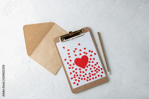 Clipboard with blank paper, red paper hearts