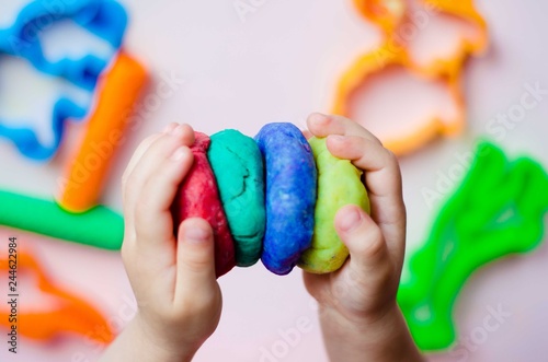 Child hands playing with colorful clay. Homemade plastiline