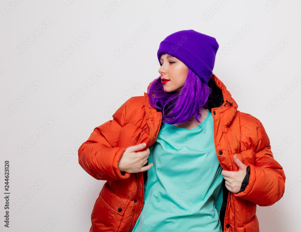 Beautiful young girl with purple hair and in orange jacket on white background.