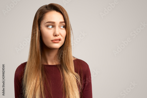 Dissatisfied female frowns face, has disgusting expression. Lovely woman feels worried, makes mistake and looks awkward. People and negative facial expressions photo