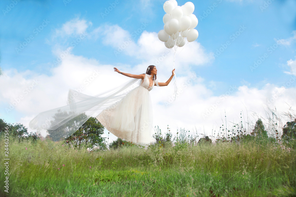 Fliegende Hochzeitsbraut mit Luftballone in der Hand Fliegende Hochzeitsbraut mit Luftballone in der Hand