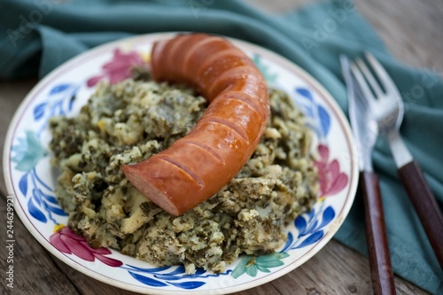 Rustic cuisine with “Boerenkool spamppot” or smoked sausage cabbage, traditional Dutch food. With a typical Dutch plate. stamppot boerenkool . photo