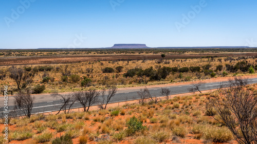 Distant view of mount Conner with Lasseter highway in central outback Australia