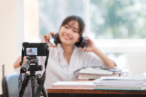 Happy Asian woman videoblog / blogger vlogger recording online course or tutorial coach presentation pass video for teaching live homework sharing online channel social media by mirrorless camera