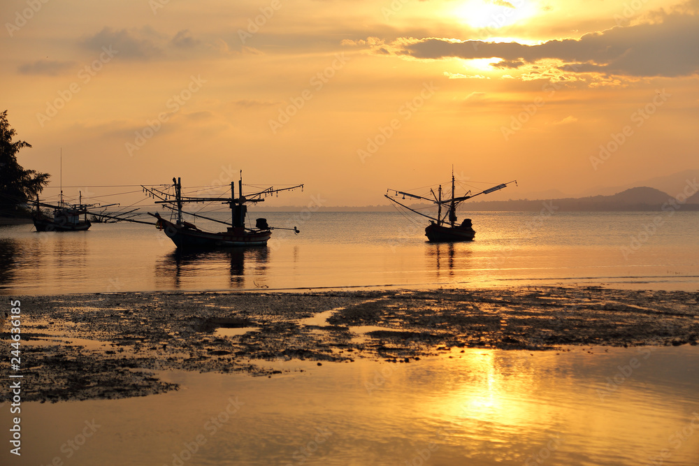 Silhouette fo fishing boats on the sea during sunset at Mae Ramphueng Beach ,Prachuap Khiri Khan province in Thailand.