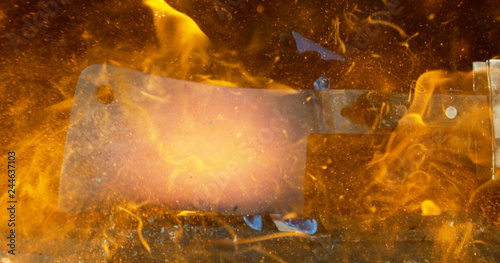 Fototapeta Naklejka Na Ścianę i Meble -  Close up of butcher knife cutting down among orange flames