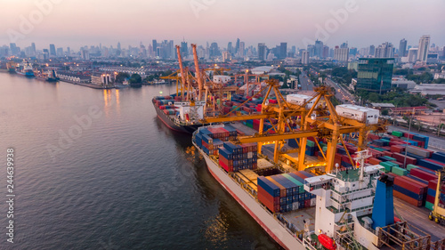 Logistics and transportation of Container Cargo ship and Cargo plane with working crane bridge in shipyard at sunrise, logistic import export and transport industry background