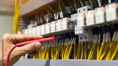 Electricians hands testing current  electric in control panel. photo