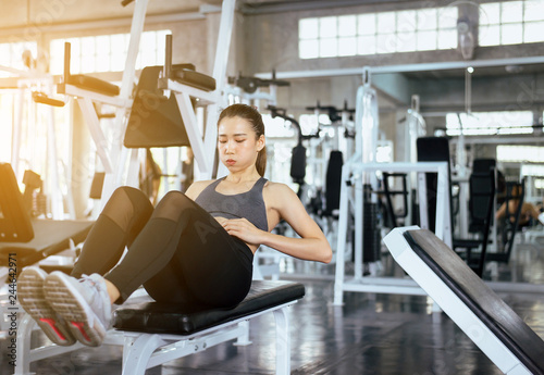 Young asian woman doing situp or crunches in gym,Female exercise muscular her stomach