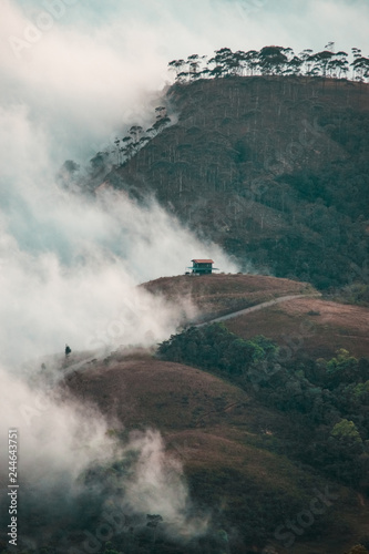 Casa rodeada de neblina y montañas 