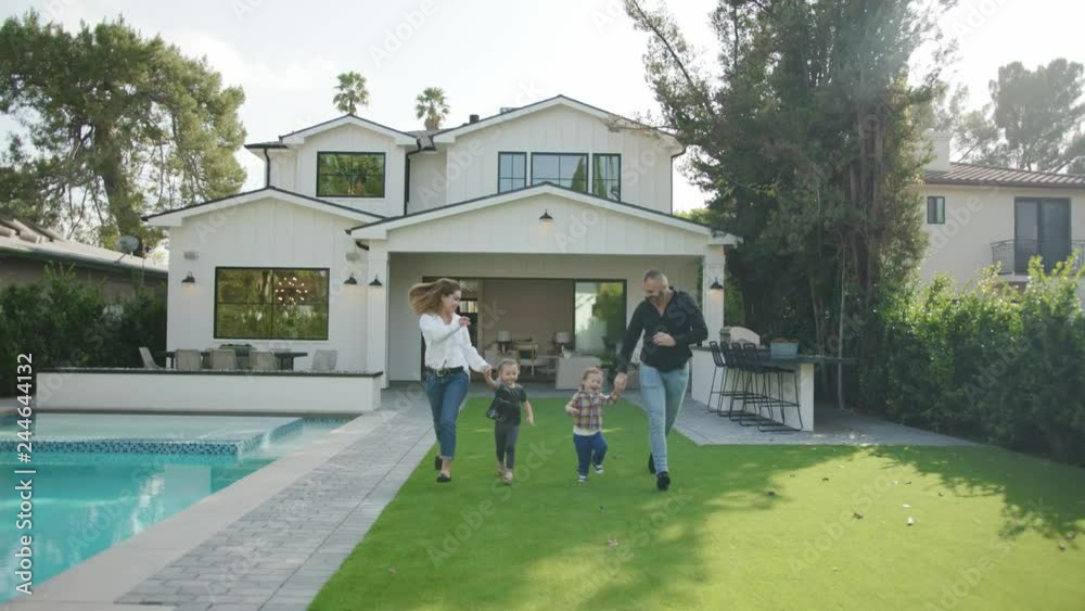 Happy family having good time at back yard of their new just purchased modern house 