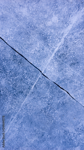 The frozen lake surface, showing a variety of textures. Blue background of Ice texture. 