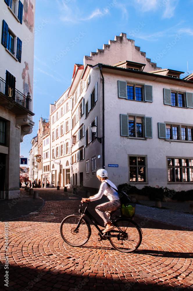 Tourist riding bicycle pass old vintage buildings in Zurich Old town Altstadt