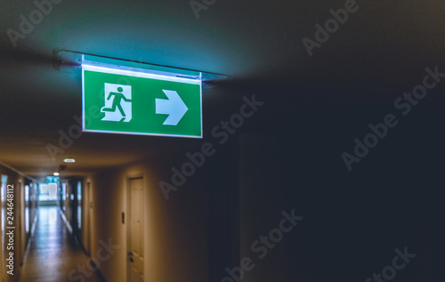 Emergency fire exit green sign at the corridor in office building., close up at the signs.