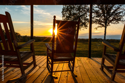 sun burst through rocking chair on front porch photo