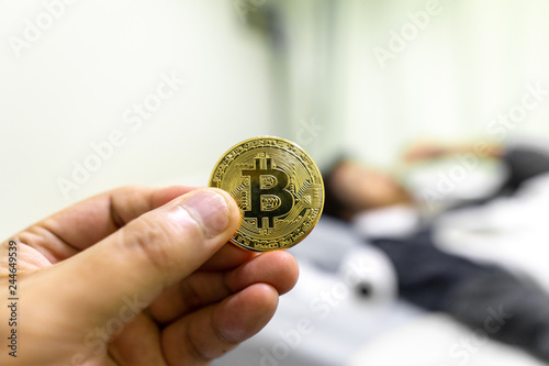 Golden Bitcoin in hand over woman patient lying at hospital bed.