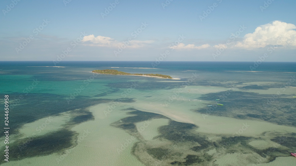 Tropical island with white sandy beach, palm trees. Aerial view of Tanduyong island with colorful reef. Seascape, ocean and beautiful beach. Philippines, Anda, Pangasinan. Travel concept.