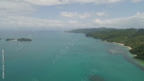 Aerial view coastline with beach and mountains covered with tropical forest in province Caramoan  Philippines. Landscape with sea  mountains and beach.