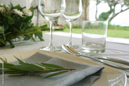 Dining set on the white table sheet with white bouquet flower background
