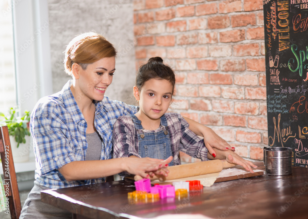 Fototapeta premium Mom and daughter prepare cookies in the kitchen