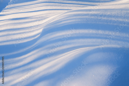 Snowdrifts, illuminated by the sun, with deep blue shadows, beautiful winter landscape, 