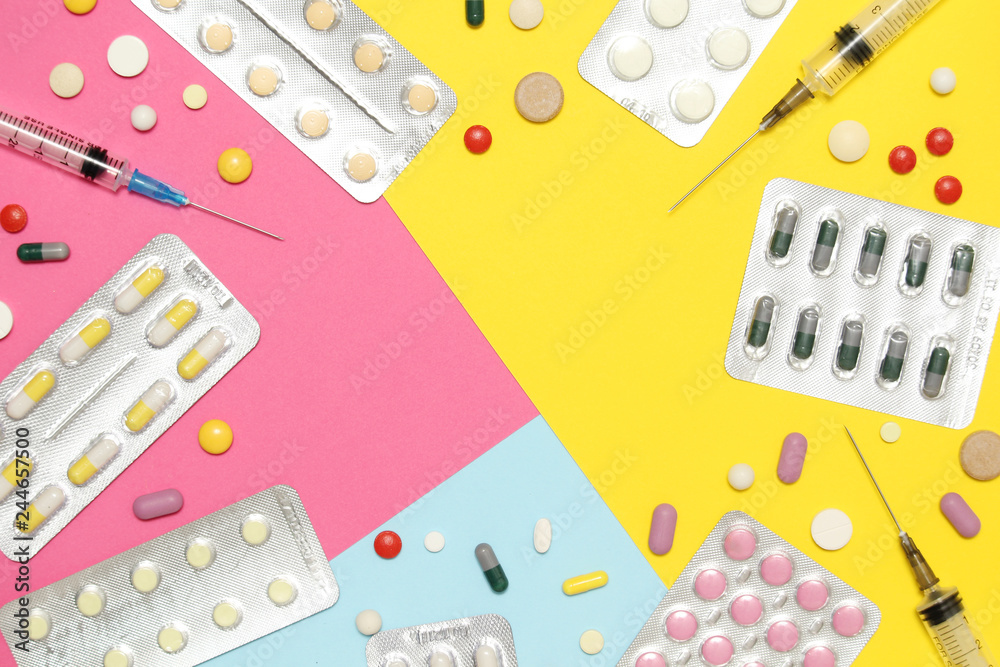 Bright background with copy space in the middle formed with different medication and pillows Bright background with copy space in the middle formed with different medication and pillows