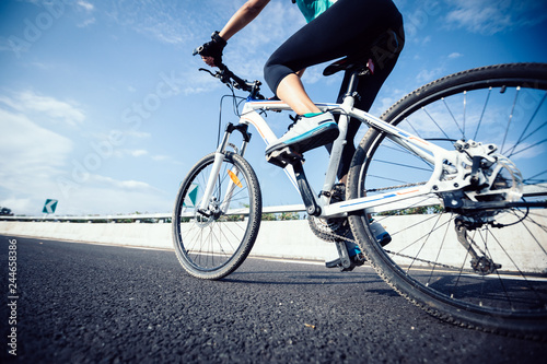Woman cyclist legs riding Mountain Bike on highway © lzf