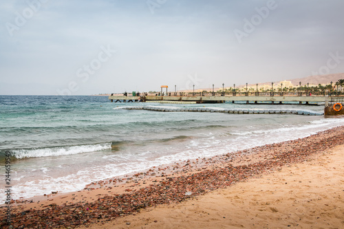 Beach, sea and pier in the water on a cloudy summer day © keleny