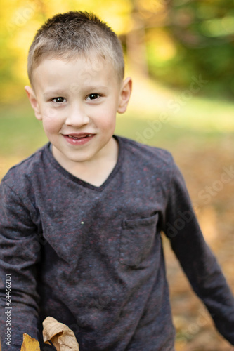 smiling young boy without front teeth in the park