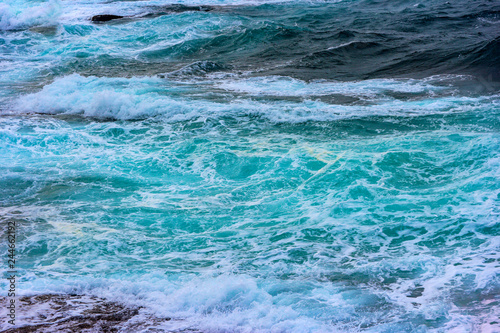 blue ocean sea water with splashing foam from windy storm.