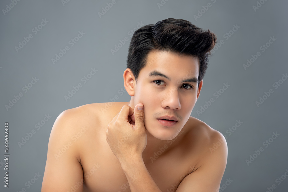 Portrait of shirtless young handsome Asian man touching his face Portrait of shirtless young handsome Asian man touching his face