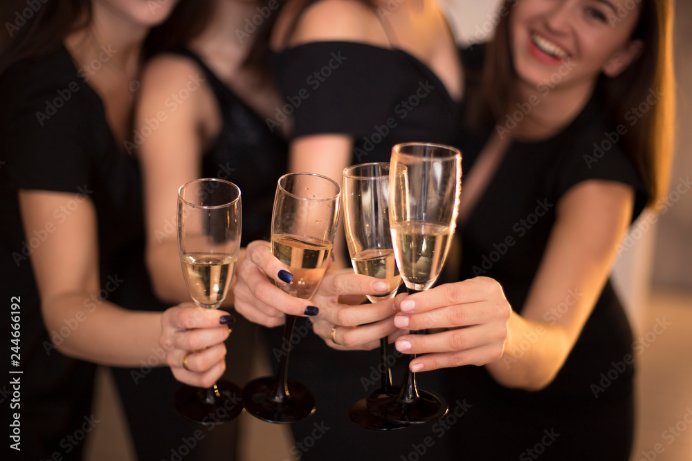 Cheers! Group of people cheering with champagne flutes with holiday lights on background with copy space. Cheers! Group of people cheering with champagne flutes with holiday lights on background with copy space.