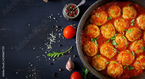 Chicken meatballs with tomato sauce in a pan. Dinner. Top view. Dark background.