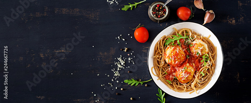 Italian pasta. Spaghetti with meatballs and parmesan cheese in bowl on dark rustic wood background.  Dinner. Banner. Top view. Slow food concept