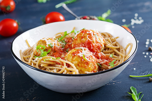 Italian pasta. Spaghetti with meatballs and parmesan cheese in bowl on dark rustic wood background. Dinner. Slow food concept