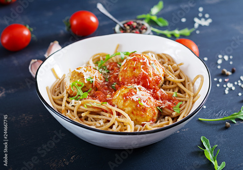 Italian pasta. Spaghetti with meatballs and parmesan cheese in bowl on dark rustic wood background. Dinner. Slow food concept