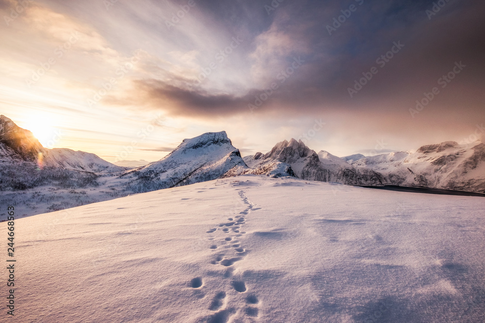 Landscape of snow mountains range with footprint on snowy at sunrise
