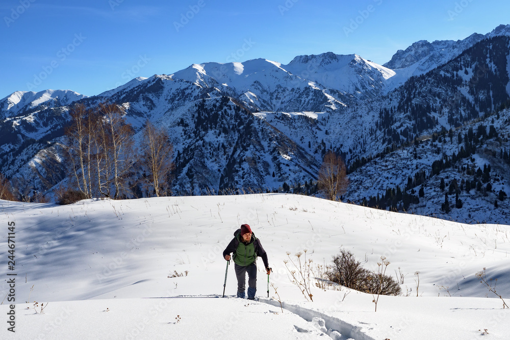 Traveler in the mountains walk on snowshoes. Winter mountain tourism. Kazakhstan