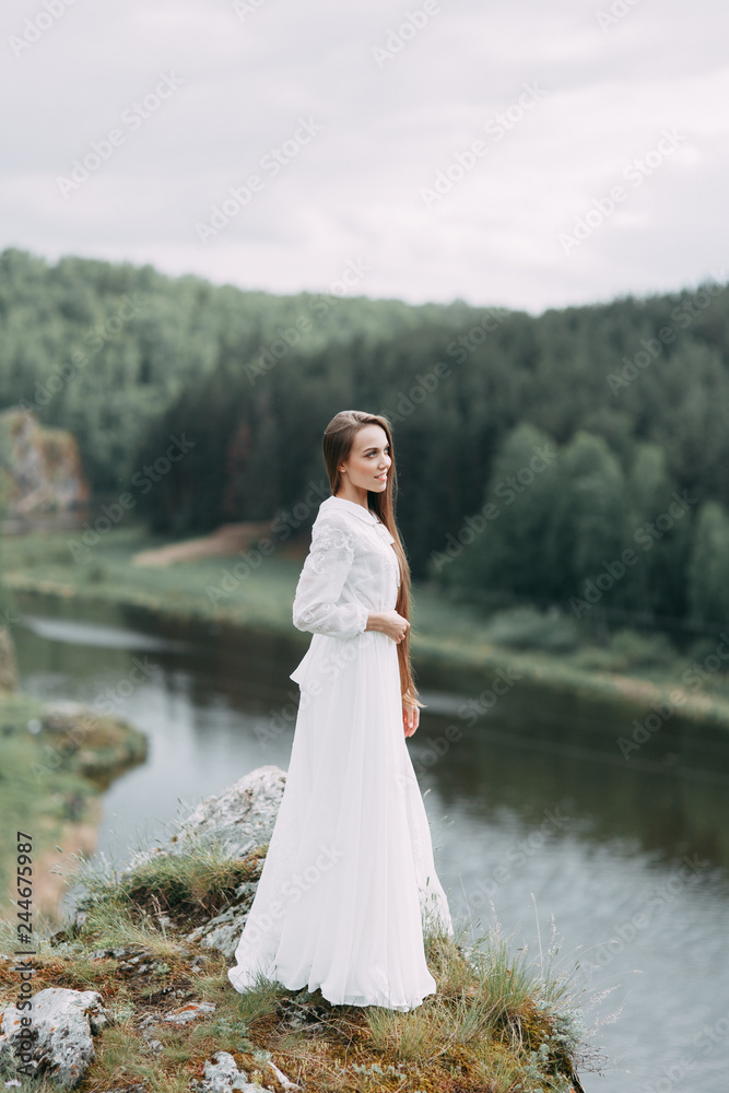 Morning bride on a beautiful panoramic location. Girl in boudoir dress and cliffs.