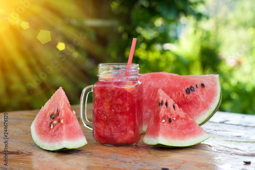 Fresh watermelon smoothie in the mason jar on wooden background. Summer, healthy organic food concept.